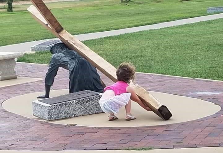 Niña ayuda a cargar la cruz